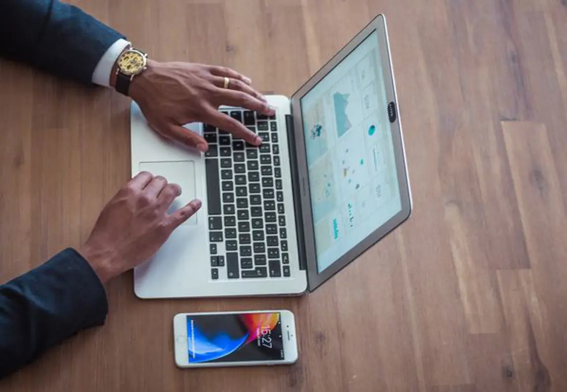 Exceptionally well manicured hands working on a laptop showing a data visual