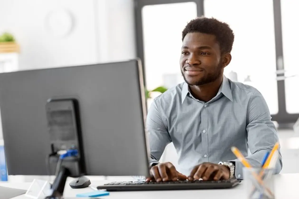 a man sitting at a desk typing on a computer