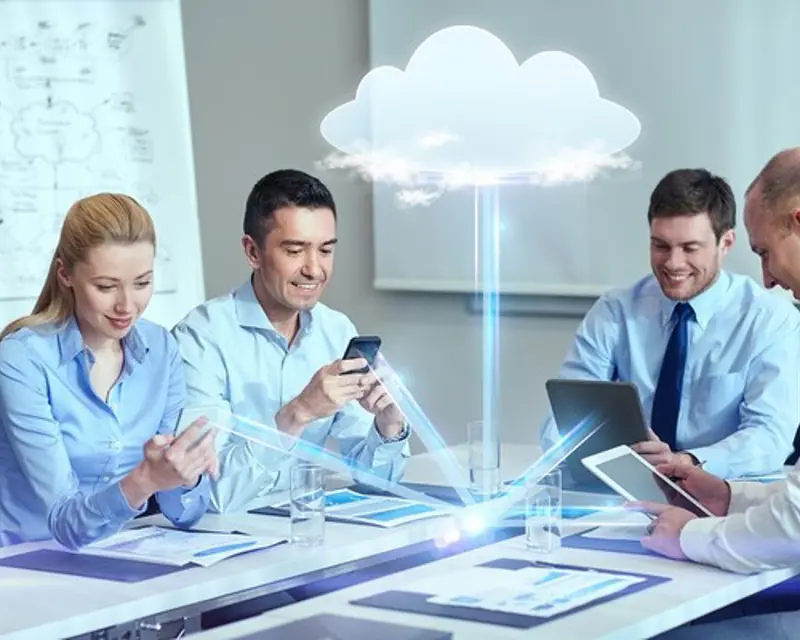 a group of people sitting at a table looking at a cloud