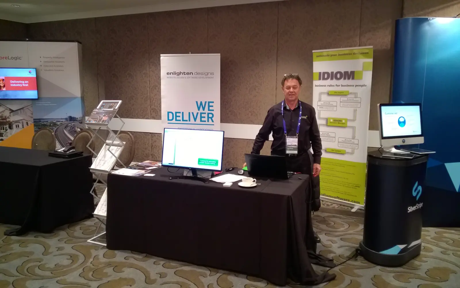 a man standing next to a table with a laptop