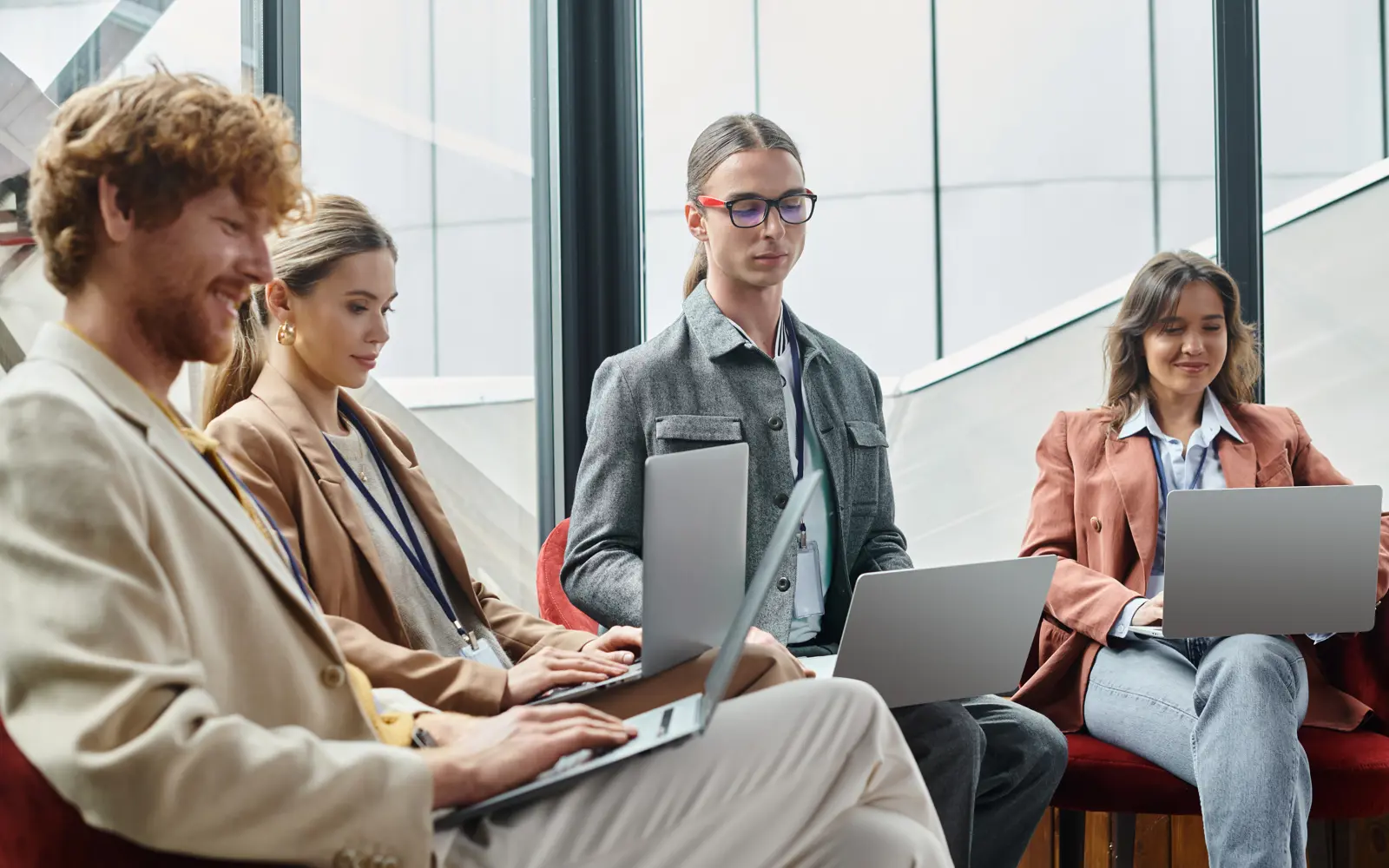 a group of people sitting in a circle using laptops