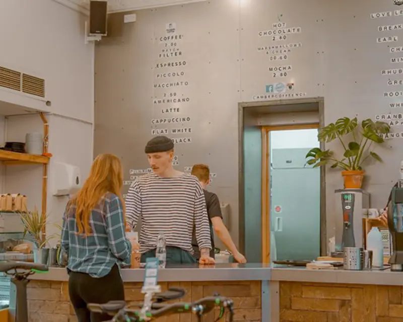 a man standing at a counter in a coffee shop