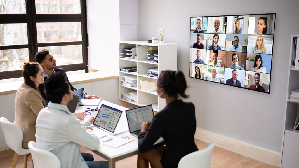 a group of people in a room with a video conference