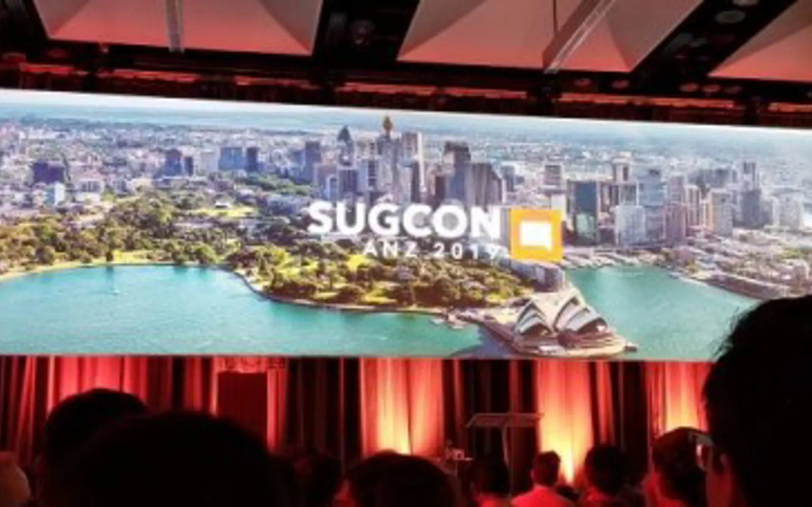 a large screen with a picture of a city and a crowd of people