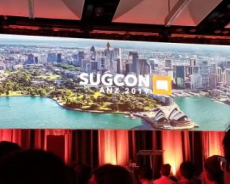 a large screen with a picture of a city and a crowd of people