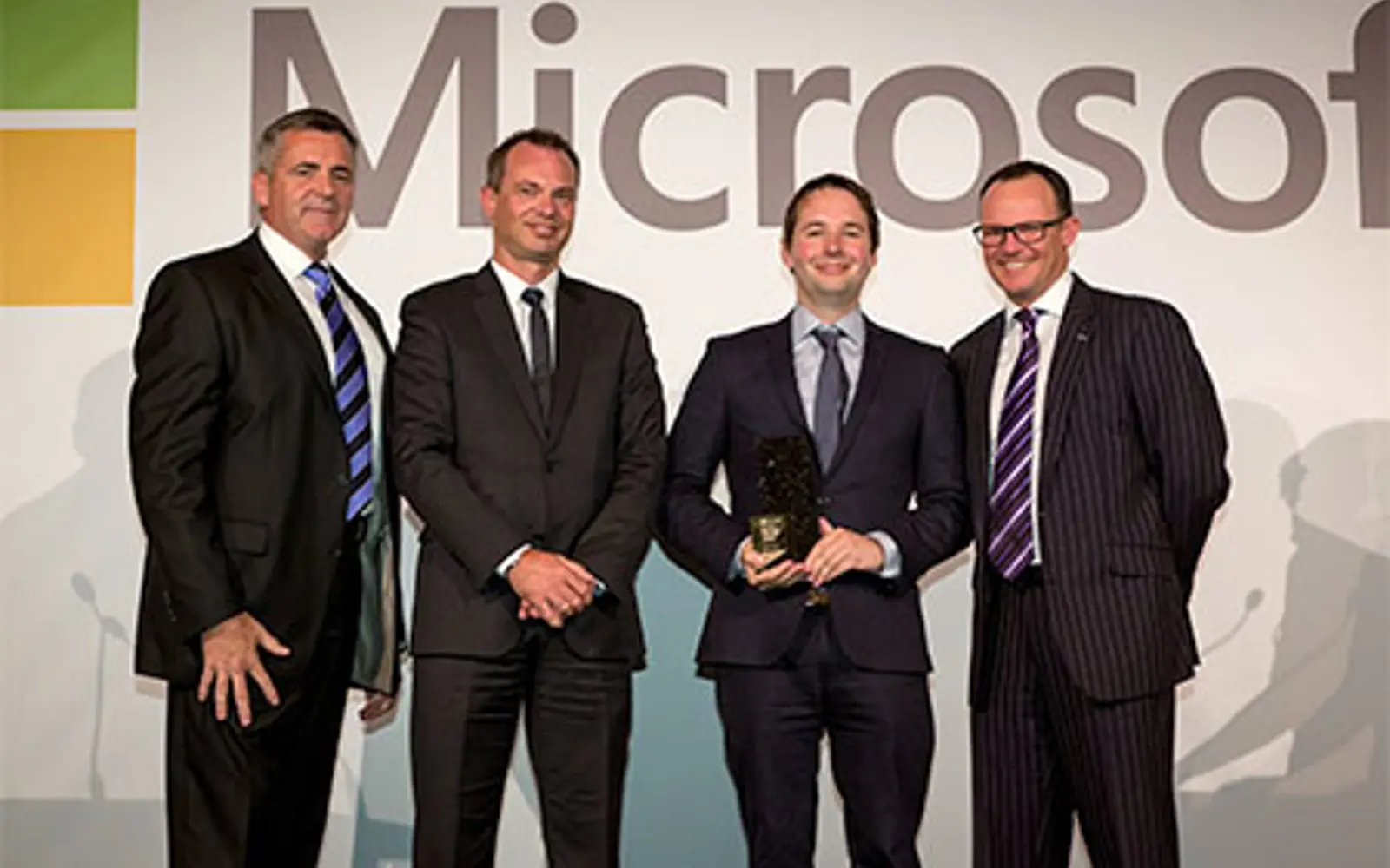 a group of men in suits holding a trophy