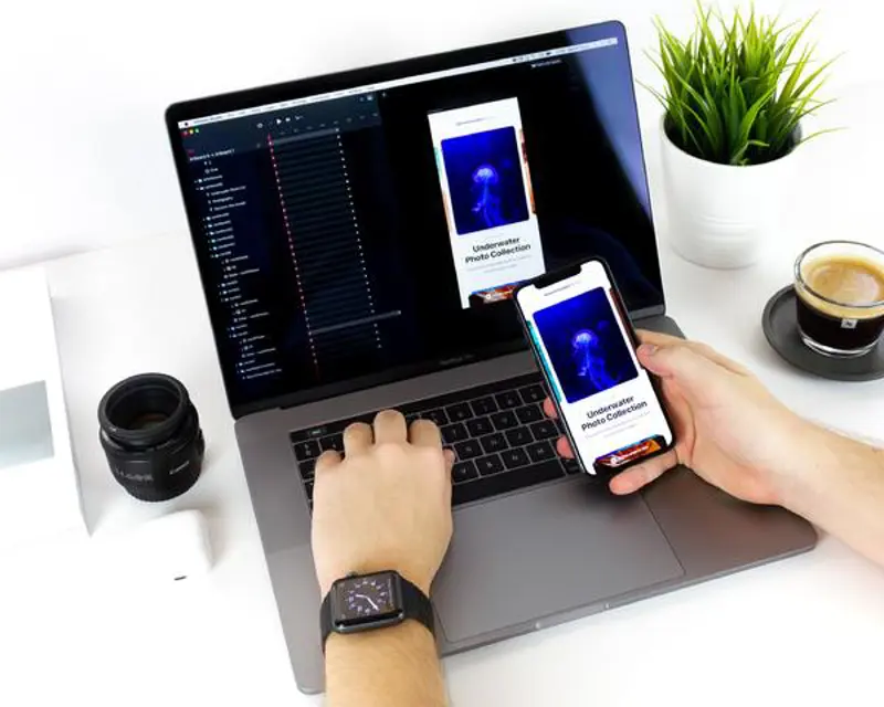 a person using a laptop and a phone