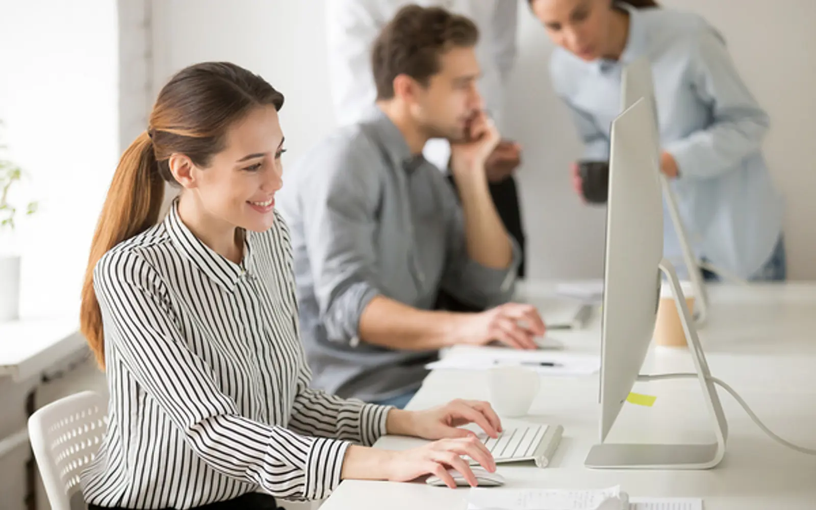a woman sitting at a desk using a computer