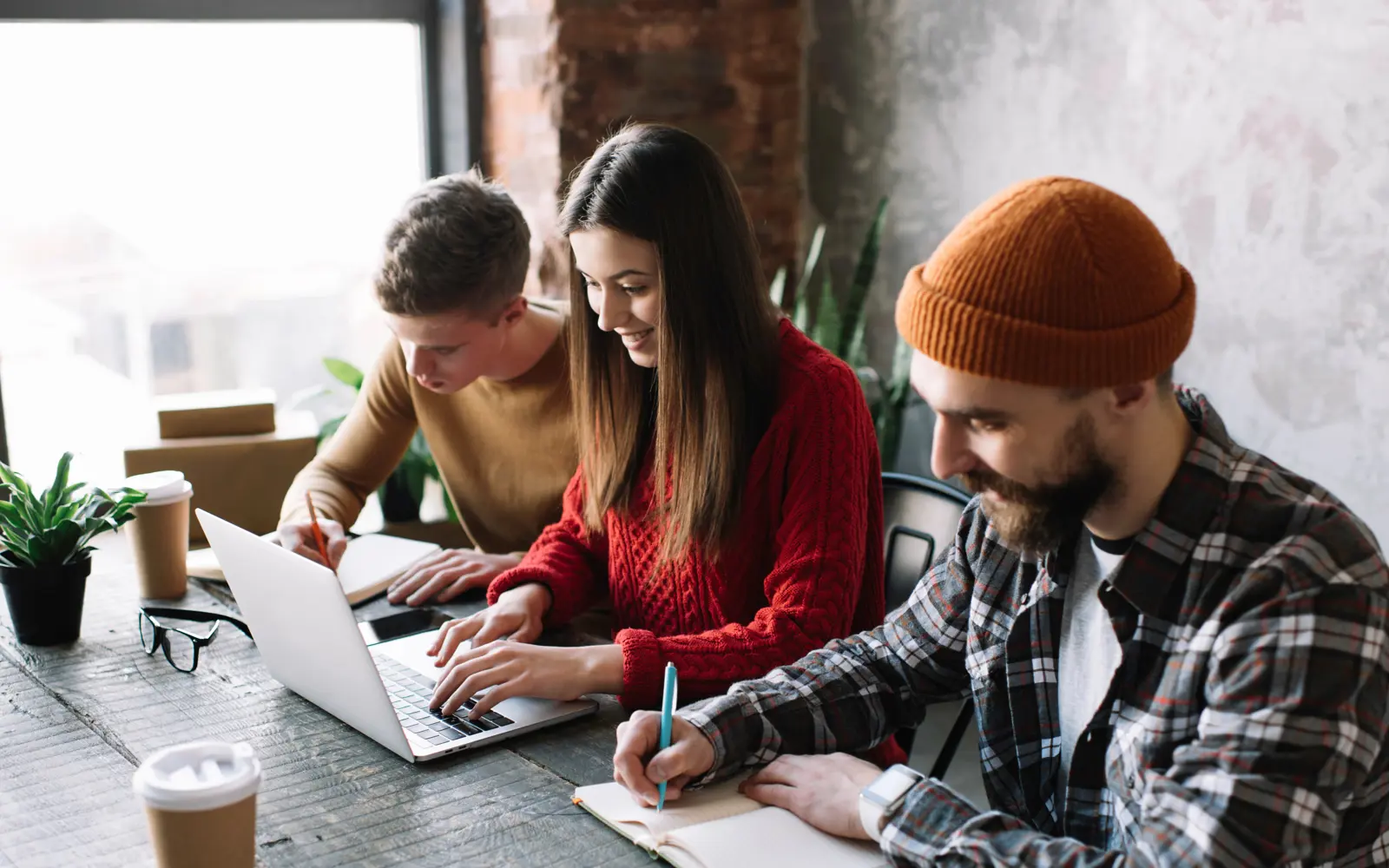 a group of people sitting at a table using a laptop
