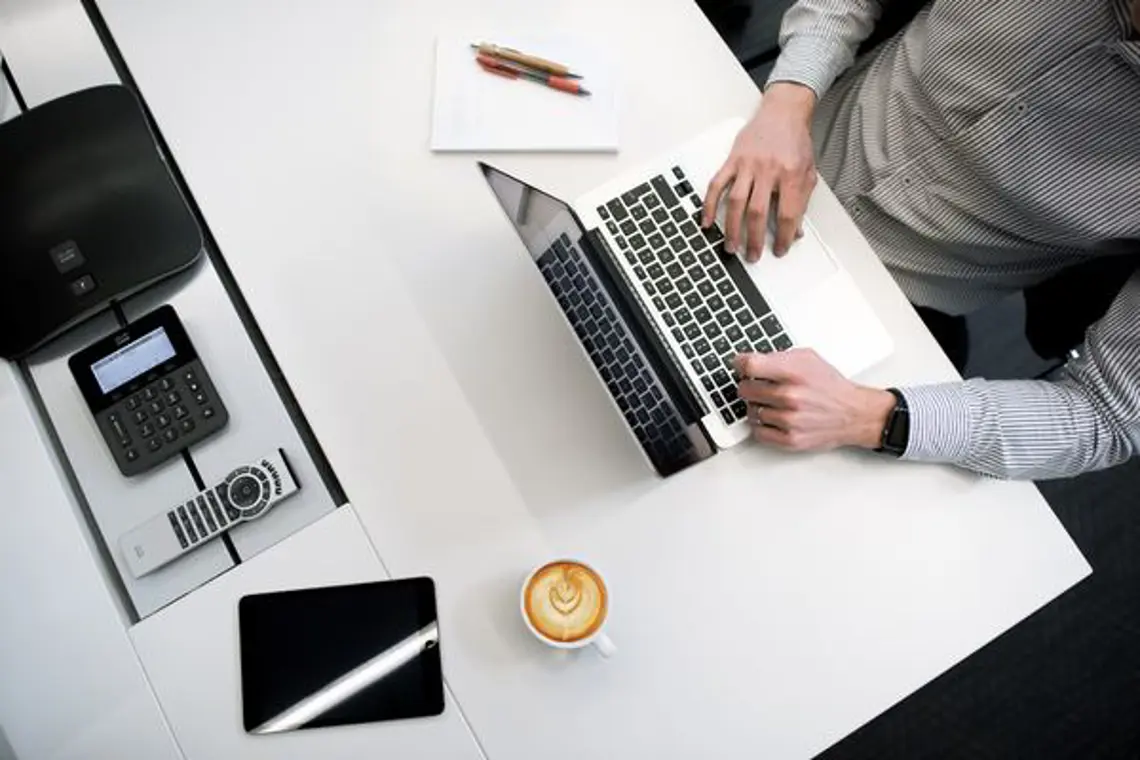 Overhead view of a person typing on a laptop