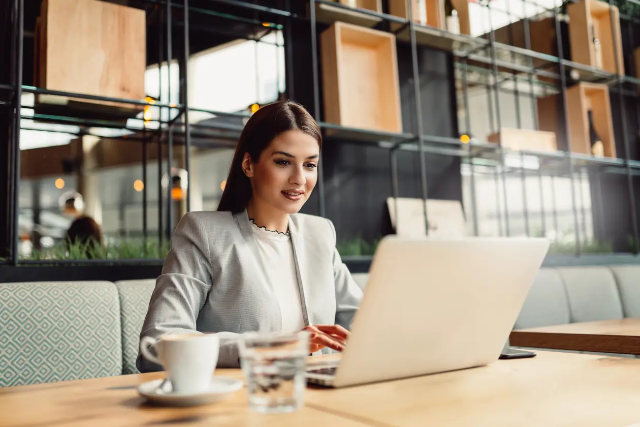 a woman sitting at a table with a laptop