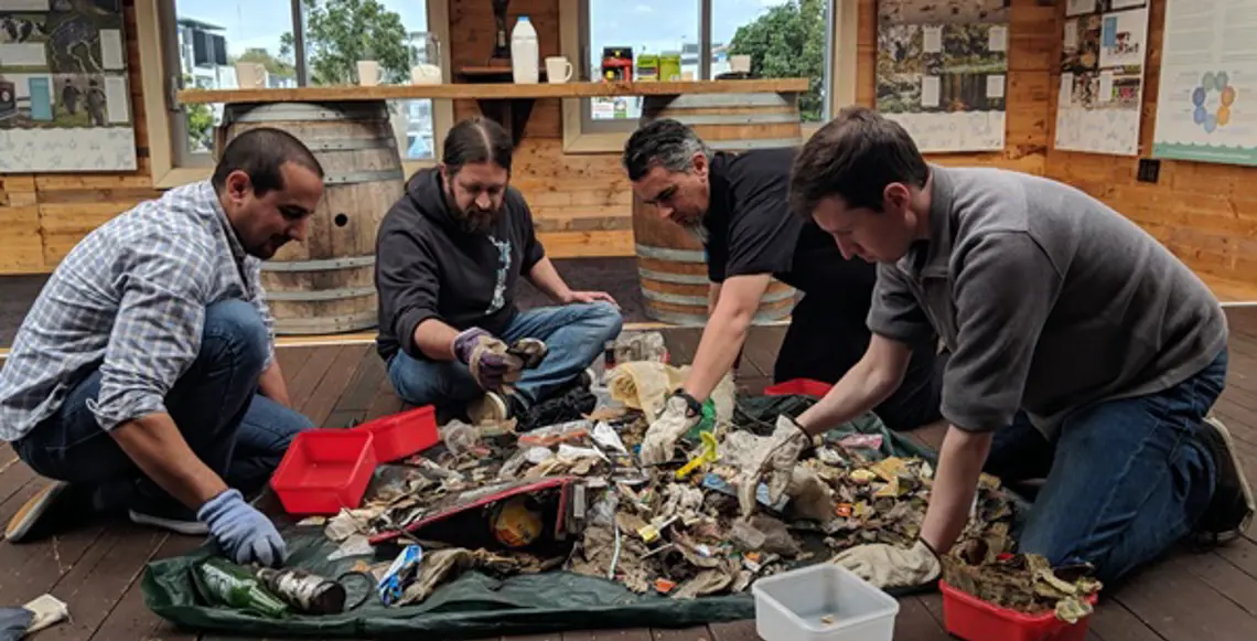 The team at Enlighten get hands on with sorting collected coastal litter at Sustainable Coastlines HQ