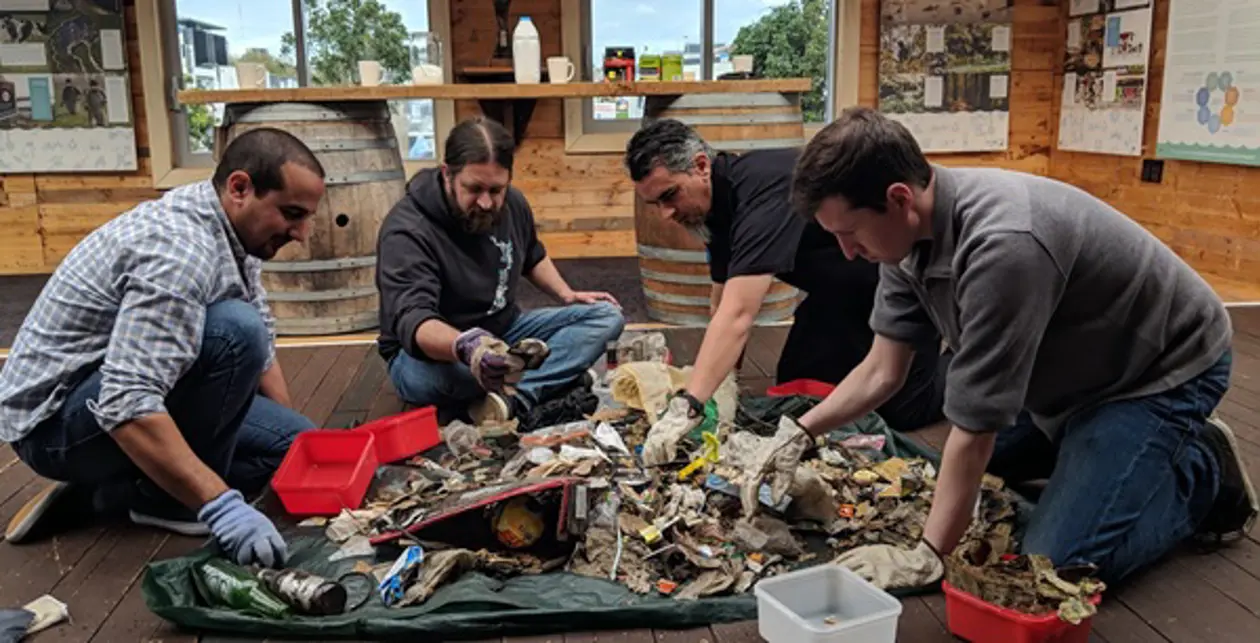 The team at Enlighten get hands on with sorting collected coastal litter at Sustainable Coastlines HQ