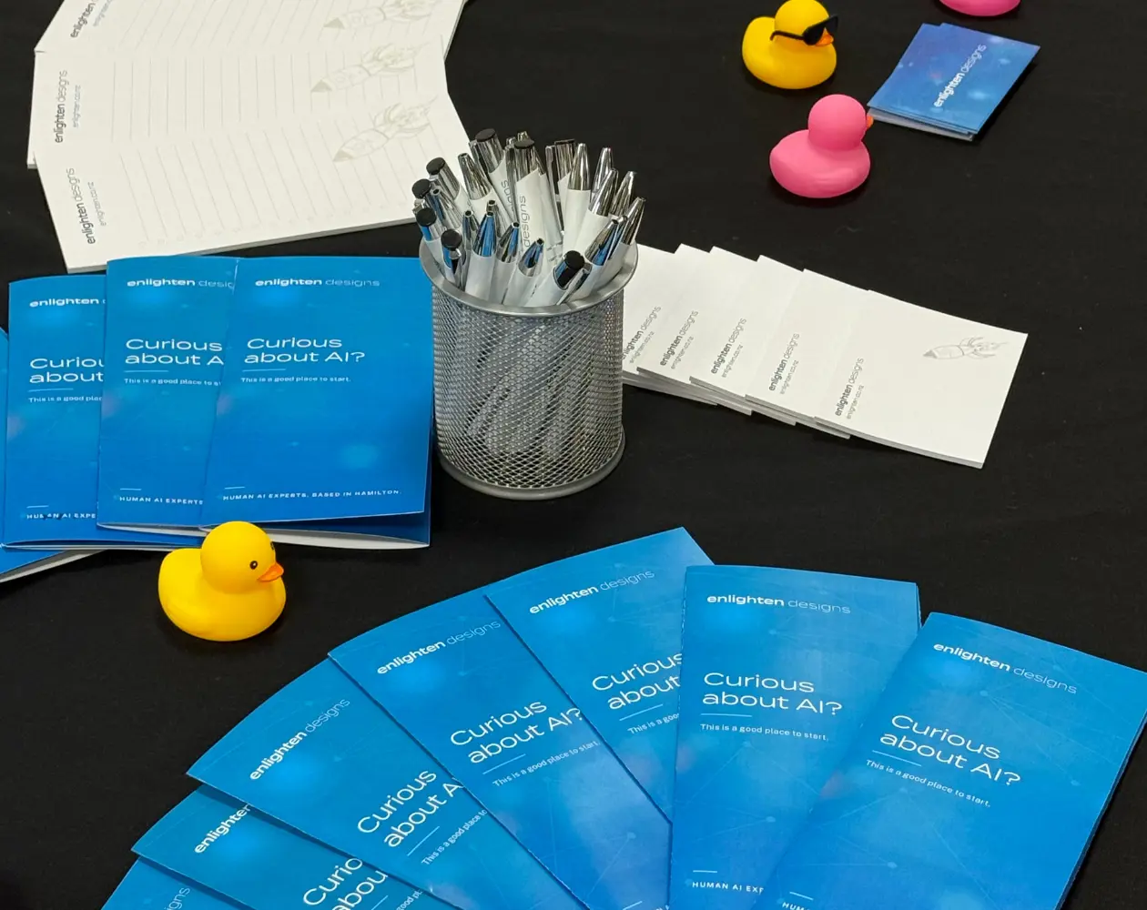 a group of pens and a group of blue papers on a table