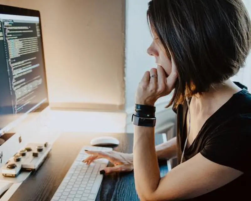 a woman sitting at a desk using a computer
