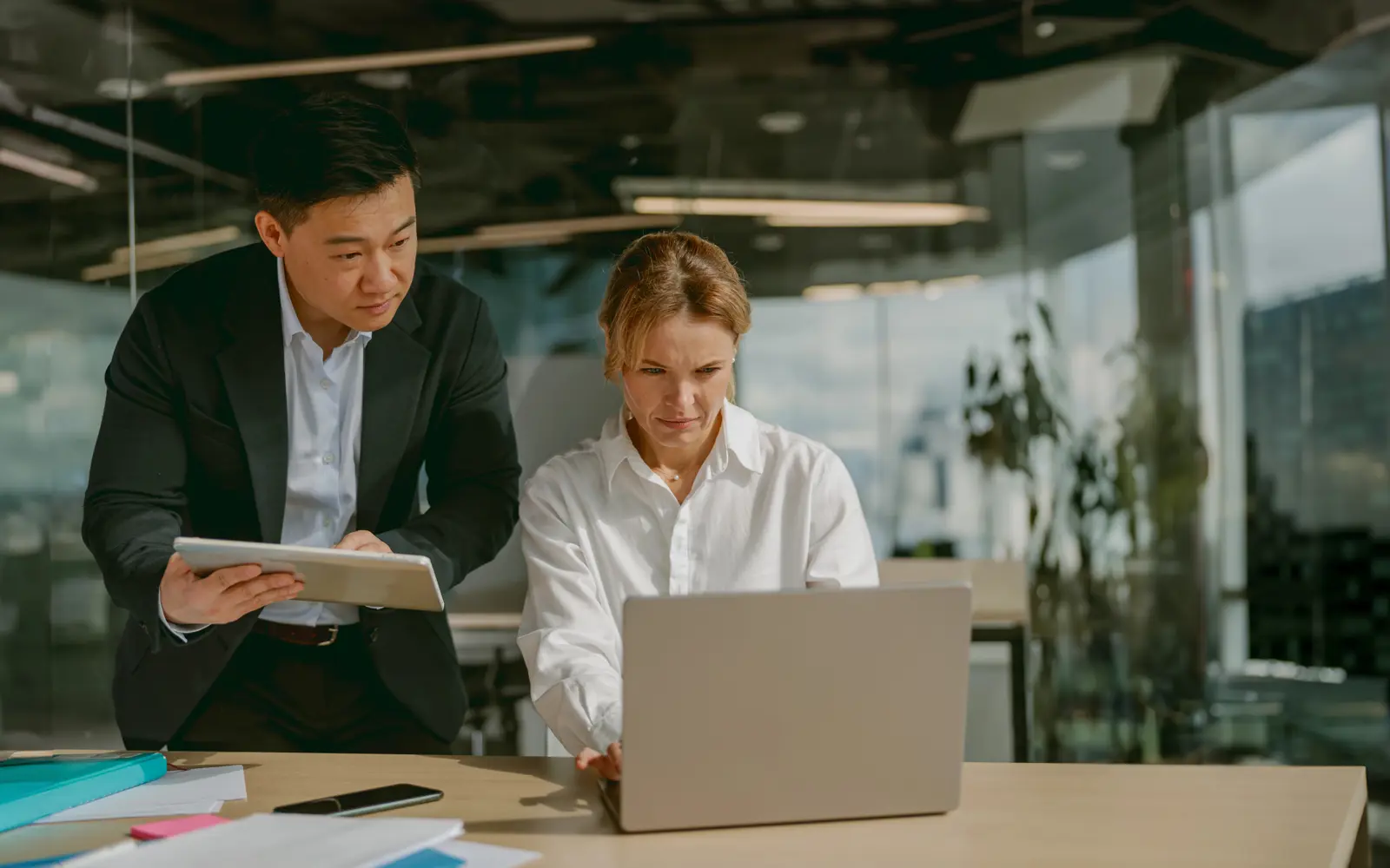 a man and woman looking at a laptop