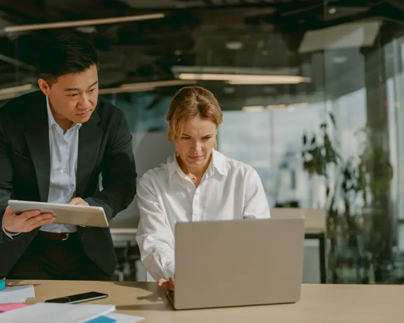 a man and woman looking at a laptop