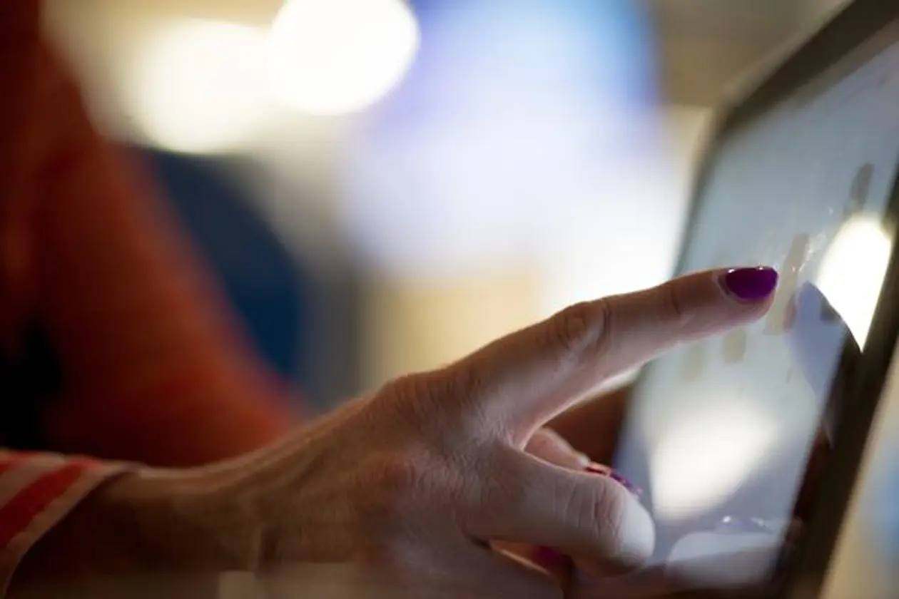a hand pointing at a tablet