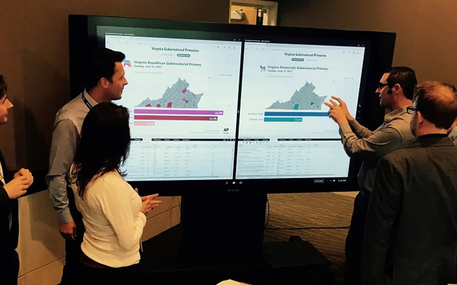 a man and woman standing in front of large screens
