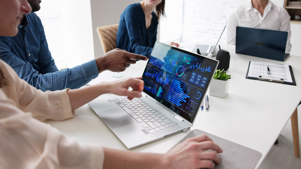 a group of people working on a laptop with data