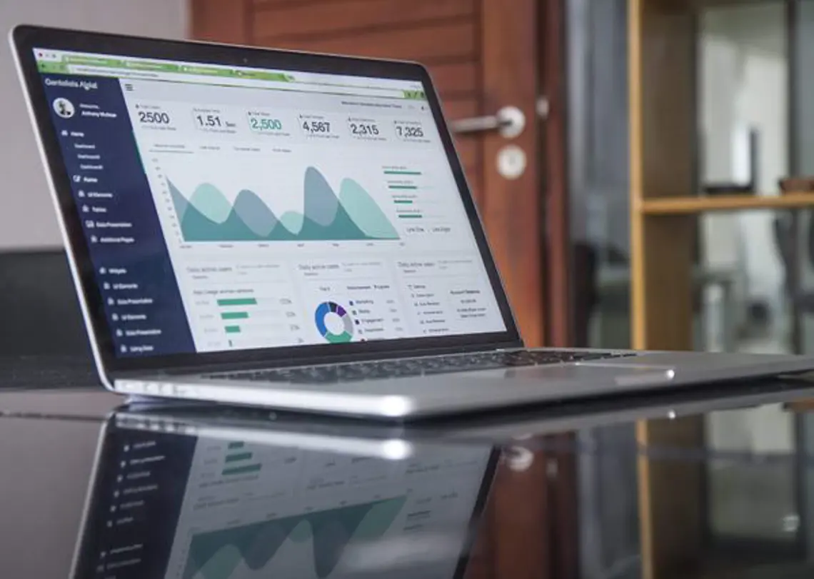 A lone laptop on a desk displaying a data visual