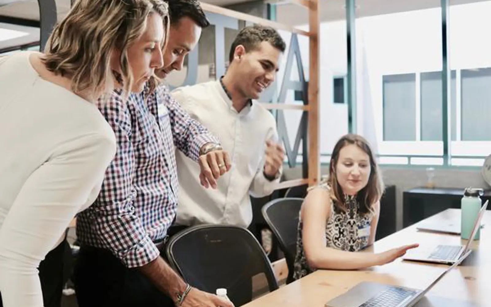 a group of people looking at a laptop