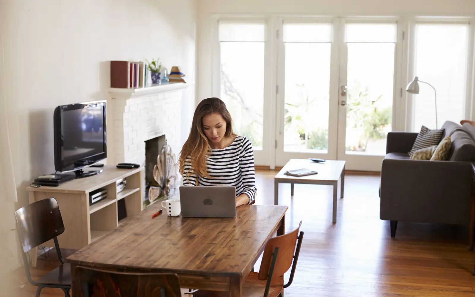 a woman sitting at a table with a laptop