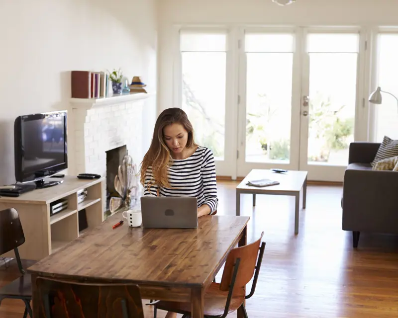a woman sitting at a table with a laptop